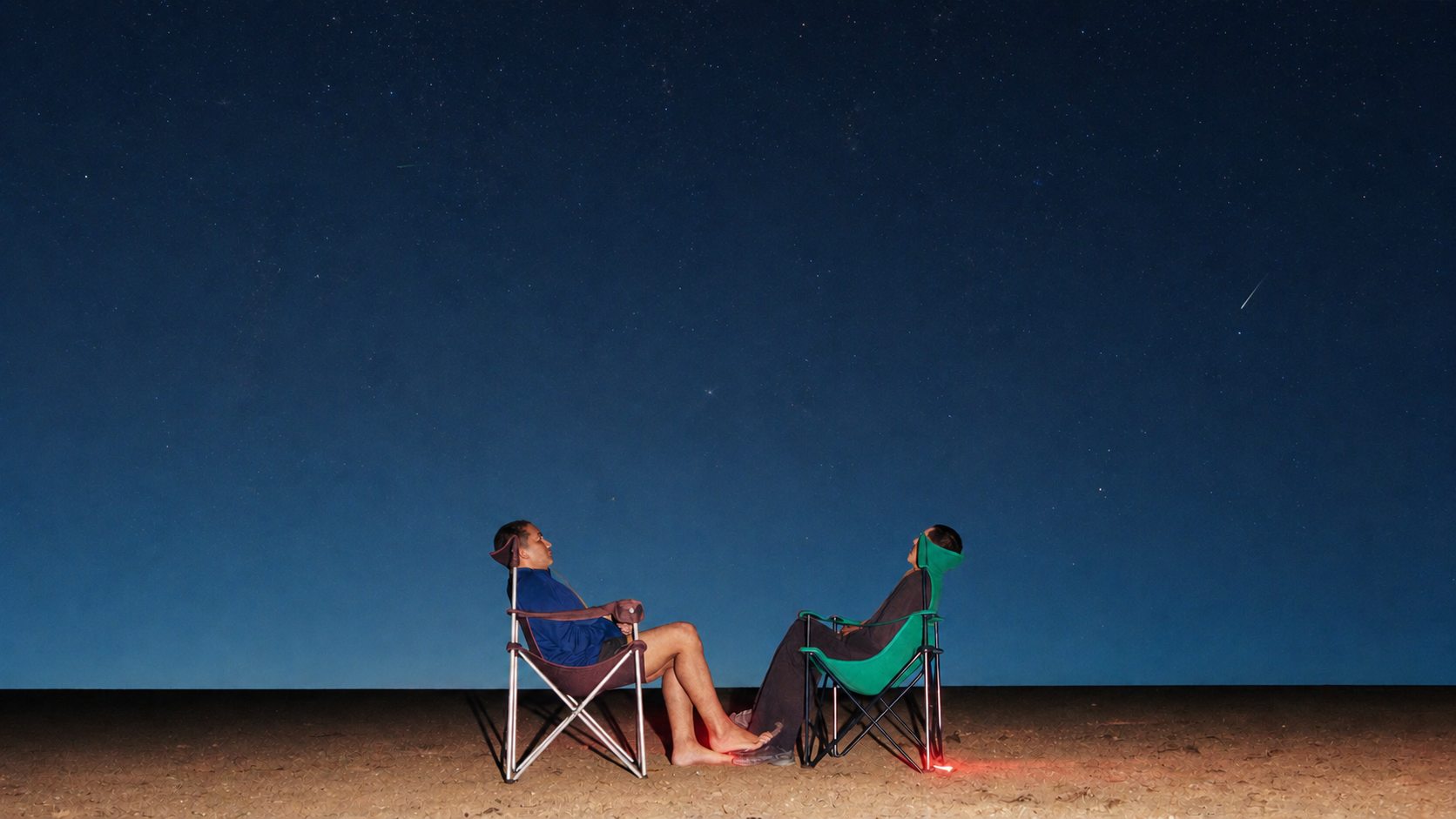 Observadores aguardando meteoros sob um céu escuro